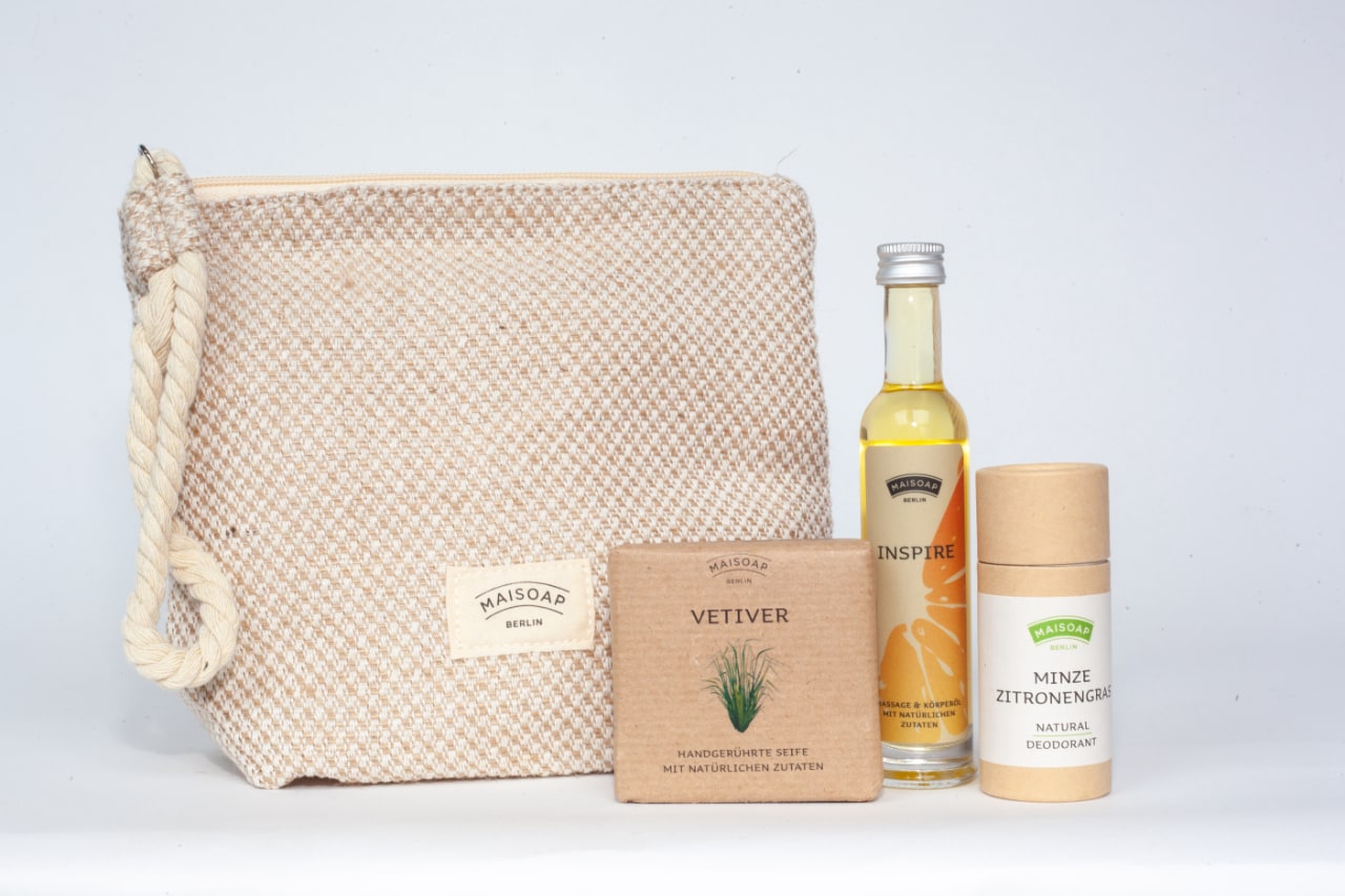 Geschenkset besteht aus Baumwoll-Leinen-Kulturtasche, Minze-Zitronengras-Deo, Inspire-Massageöl & einer Vetiver-Seife